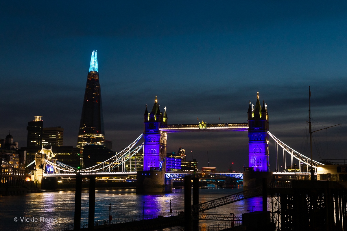 Tower Bridge and the London shard seen from Wapping are illuminated in blue